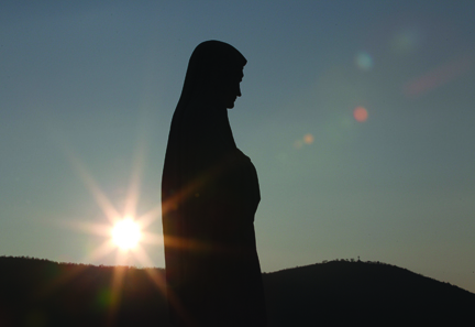 SUN SETS BEHIND STATUE OF MARY ON APPARITION HILL IN MEDJUGORJE