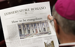 BISHOP READS VATICAN'S NEWSPAPER BEFORE MEETING OF SYNOD OF BISHOPS ON THE NEW EVANGELIZATION
