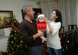 CATHOLIC COUPLE TRY SANTA HAT ON BABY SARAH AT HOME IN BETHLEHEM