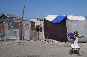 Un fillette haïtienne marche au milieu d'un camp de personnes déplacées. Depuis le séisme qui a frappé Haïti en 2010, 300 000 personnes vivent encore dans des abris de fortune (photo CNSSwoan Parker, Reuters).