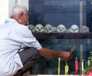Un villageois du Cambodge brûle de l'encens devant un mémorial où sont exposés plus de 8000 crânes de victimes des khmers rouges (photo CNS/Reuters).