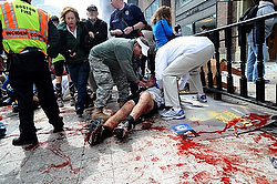 Un spectateur blessé reçoit de l'aide à la suite des explosions du Marathon de Boston (photo CNS/MetroWest Daily News/Ken McGagh, via Reuters).
