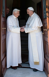 Le pape François accueille le pape émérite Benoît XVI à sa nouvelle résidence dans les jardins du Vatican (photo CNS/L'Ossevatore Romano via Reuters).