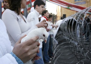 En 2007, des membres d'une organisation manifestaient avec des colombes en signe de paix devant une barrière de fils barbelés séparant des factions rivales à Beyrouth, au Liban, (CNS photo/Jamal Saidi, Reuters).