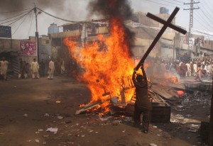 Un islamiste brûle une croix lors de la mise à sac d'un quartier chrétien à Lahore, Pakistan manifestation en mars 2013.