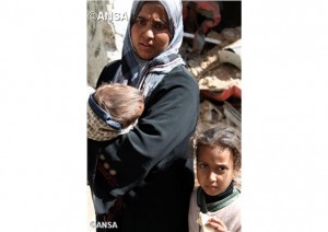 `Rama, une mère et ses enfants attendent la distribution de nourriture (photo ANSA).