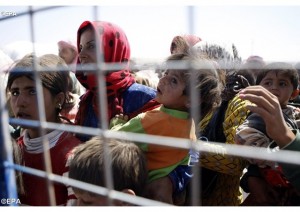 Une famille syrienne attend à la frontière avec la Turquie, pour fuir son pays, en septembre dernier (photo: EPA)