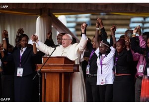 Le Pape François tenant la main de jeunes Kenyans durant son intervention. - AFP