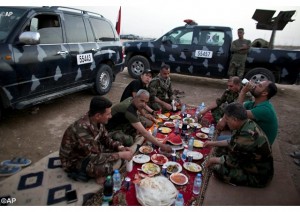 Des policiers irakiens partageant le repas de rupture du jeûne, le 7 juin 2016 près de Fallujah. - AP